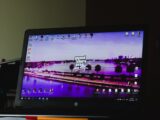 black flat screen computer monitor turned on beside black computer keyboard