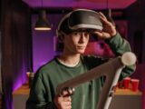 A young man explores virtual reality gaming with a headset and controllers in a cozy indoor setting.