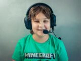 A young boy wearing headphones and a green shirt