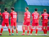 Football players in red uniforms from FC King standing on a field in Hà Nội, Vietnam.