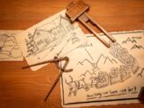 a bunch of drawings on a table with a pair of scissors