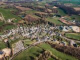 an aerial view of a small town surrounded by green fields