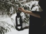 a person holding a lantern in the snow