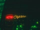 A neon sign is lit up on the side of a building