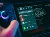 Hand holding a gaming device with game menu