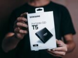 Close-up of a person holding a Samsung T5 Portable SSD box, emphasizing modern technology.