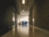 A long hallway with brick walls and bright lighting.