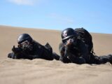 a couple of people that are laying in the sand