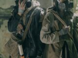 Two individuals in survival gear navigate a gritty urban post-apocalyptic setting.
