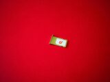 A clean image of a SIM card tray displayed on a vibrant red background.