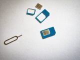 Close-up of SIM cards and ejector tool on white background, emphasizing telecommunication technology.