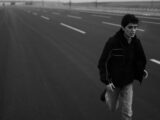 Young man running on an empty highway