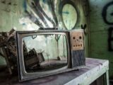 vintage TV on gray wooden table inside room