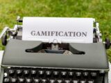 a close up of a typewriter with a paper that reads gamification
