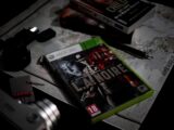 a video game sitting on top of a table next to a pair of headphones