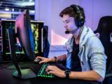 a man wearing a headset sitting in front of a computer