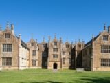 A beautiful historic English manor set against a clear blue sky, showcasing classic architecture.