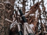 Detailed view of swords against a snowy tree in a winter forest setting.