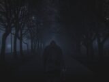 person walking between trees