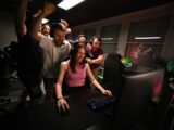 A group of people standing around a computer
