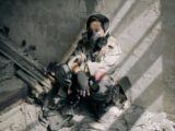 A young person in a gas mask sits in a decaying, abandoned building, evoking themes of survival and desolation.