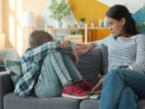Mother comforts upset child on the sofa