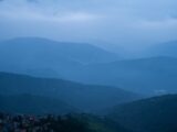 Misty blue mountains with a village below