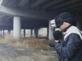 Man wearing vr headset under a bridge